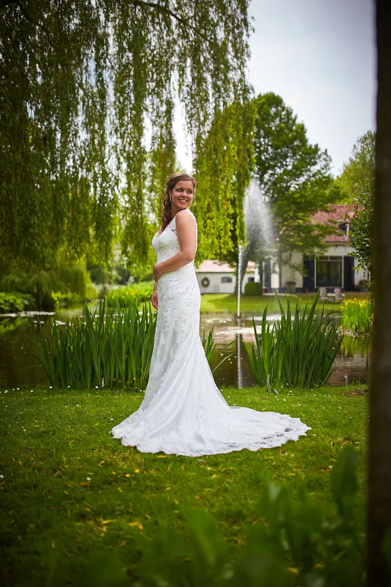 Nadine op het gazon bij de fontein, de wilgen erachter