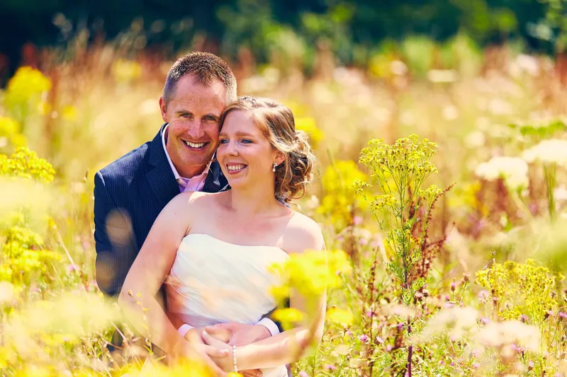 Linsey en Tim lachen tussen de gele bloemen