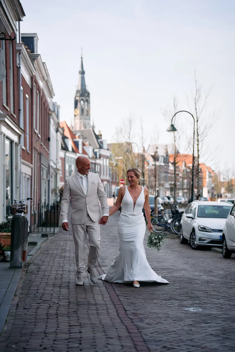 Danitsja en Brian lopen door een straatje met een kerktoren aan het eind