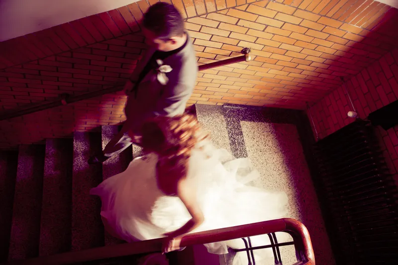 Inge loopt een trap af langs een rode bakstenen wand