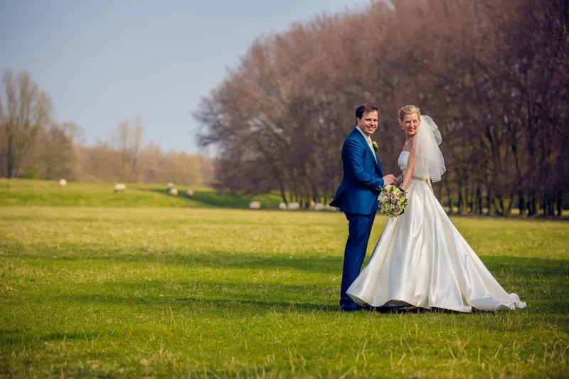 Danielle en Benjamin op een groot grasveld voor een rij bomen
