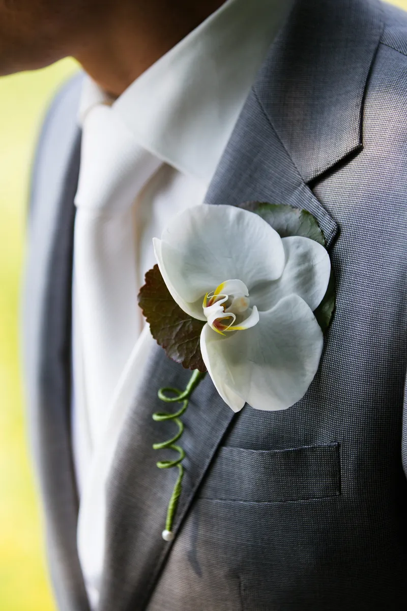 Een witte orchidee op de revers van Dennis
