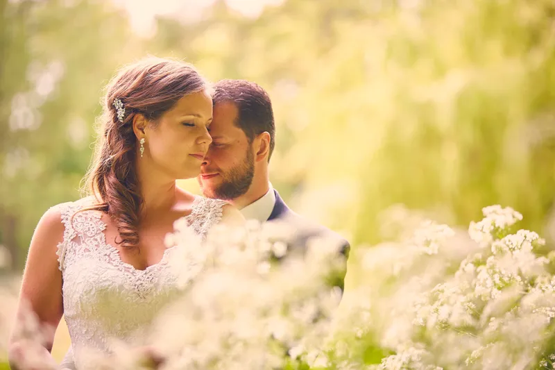 Robbert en Nadine met de gezichten dicht bij elkaar tussen de bloemen