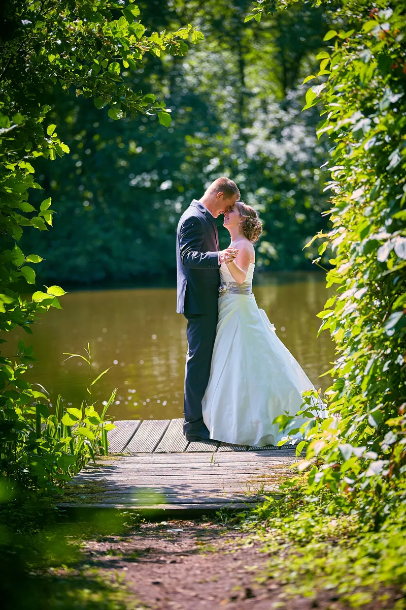 Linsey en Tim kussen op een houten steiger tussen de bomen
