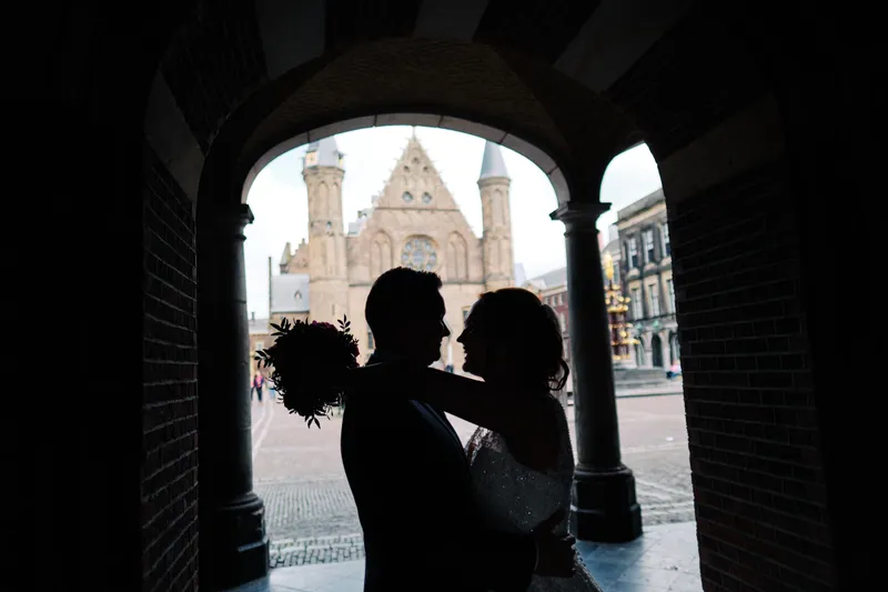 Stefan en Victoria als silhouet in de poort van het Binnenhof