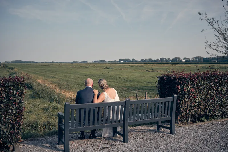 Elles en Bram op het bankje, uitkijkend over de polder