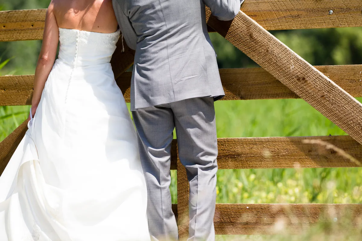 Dennis en Rebecca van achteren bij een houten hek