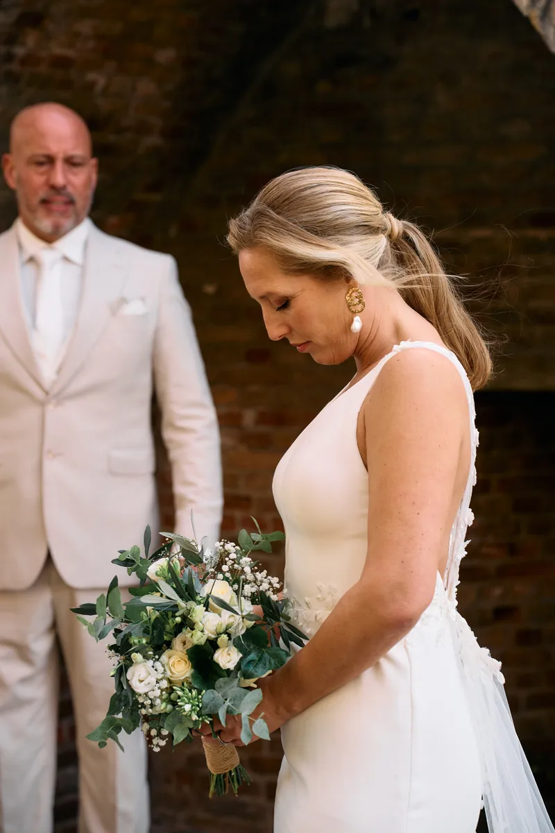 Danitsja kijkt naar haar boeket terwijl Brian naast haar staat