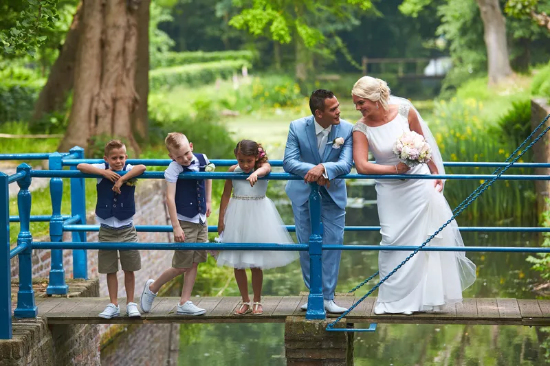 Het gezin op een bruggetje met een blauw hek