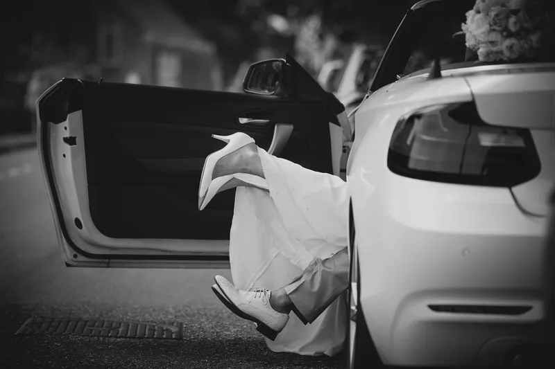 De jurk hangt uit de open achterklep van de auto