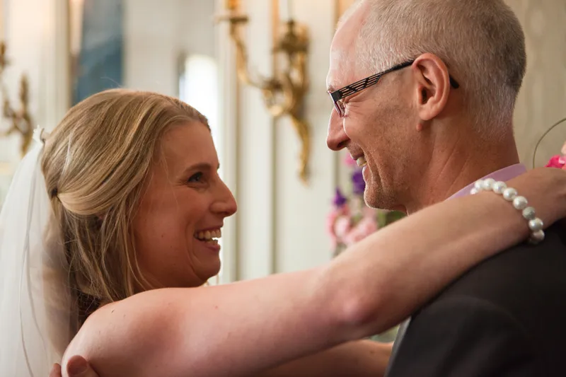 Loes omhelst lachend haar vader na de ceremonie