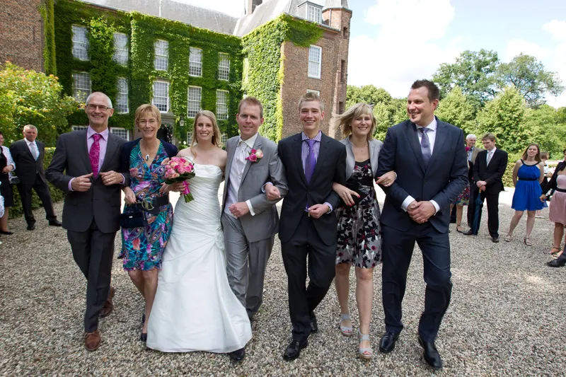 Loes, Jan en vrienden lopen arm in arm over de oprit voor het slot