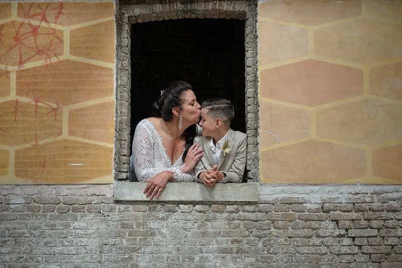 Regina geeft haar zoon een kus in het raam van de oude fabriek