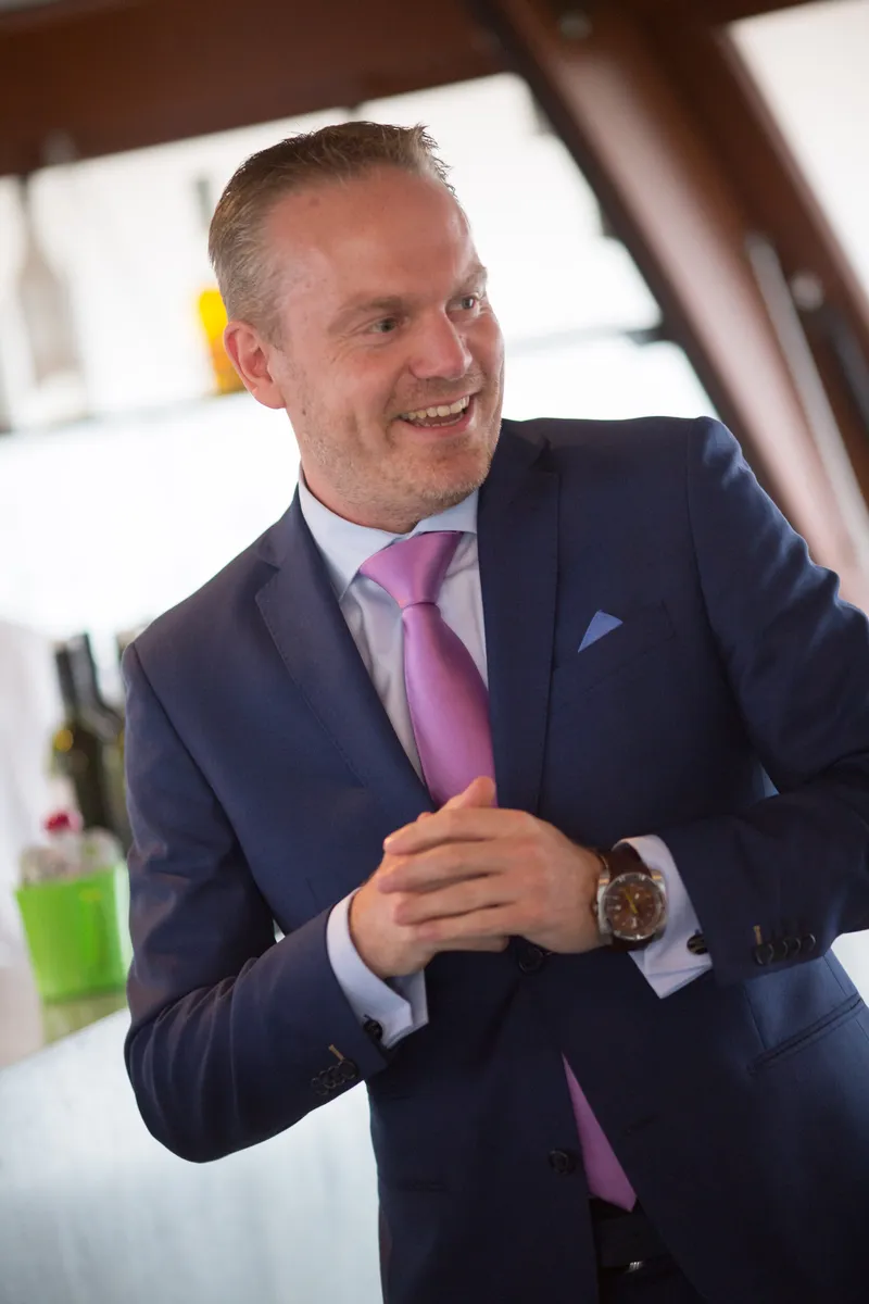 Hans luistert lachend naar de speeches