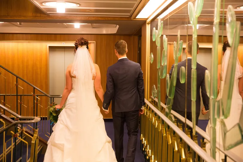 Anne en Hans lopen door de gang met houten wanden