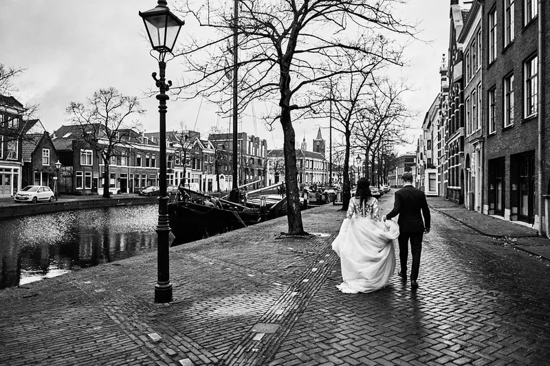 Kimberley en Mike lopen langs de gracht, tussen kale bomen en een lantaarnpaal