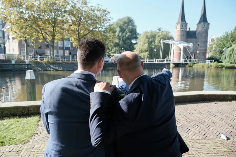 Mathijs en Jeroen bij de gracht bij de Oostpoort, een van hen wijst naar het water