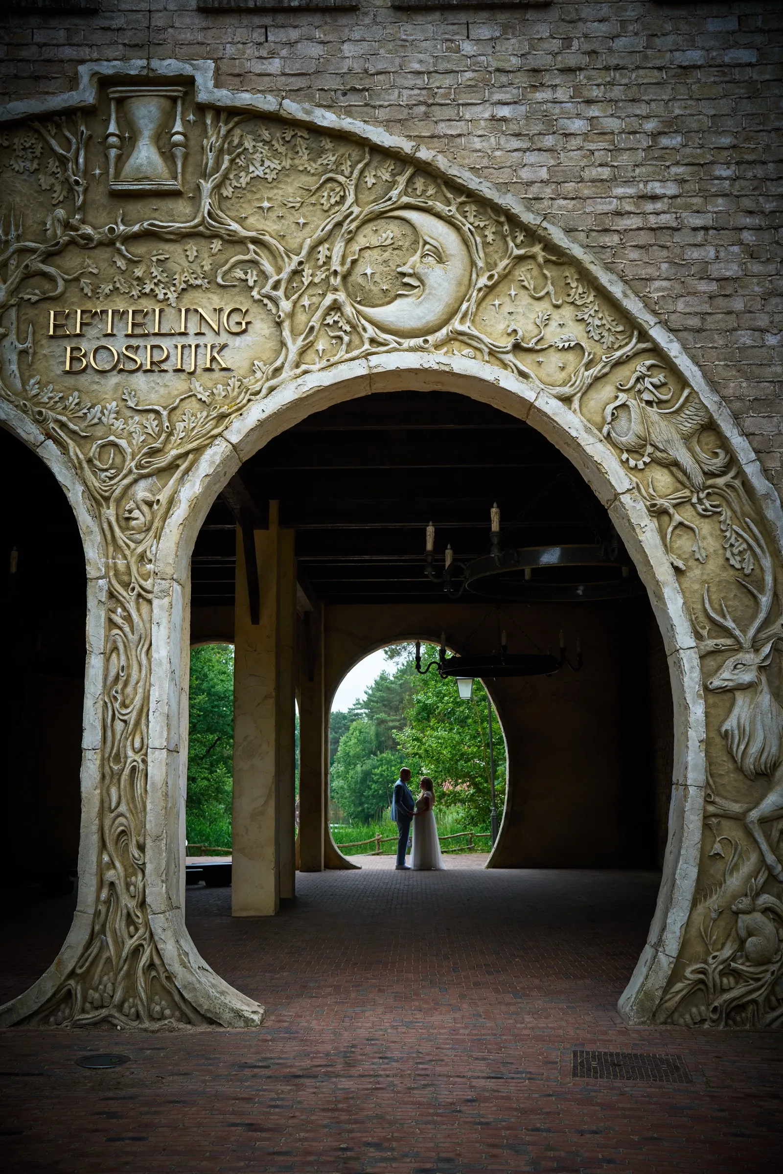Annemarie en Jan in de verte onder de sierlijke poort van Efteling Bosrijk