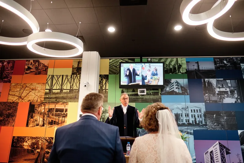 De trouwambtenaar in de zaal met de kleurige wand
