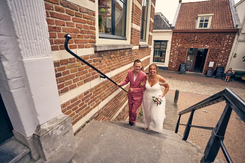 Diliana en Olav lopen hand in hand naar de ingang van het stadhuis
