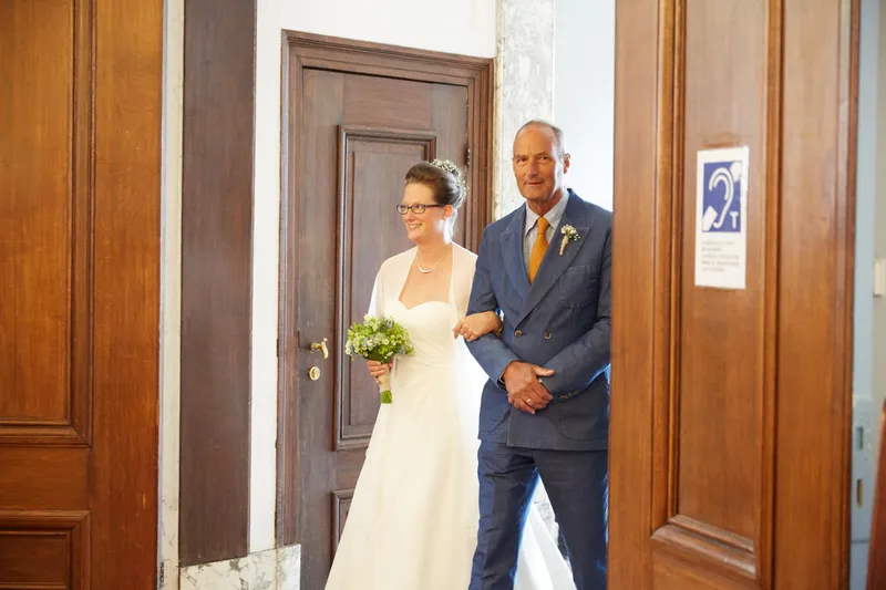 Marjolein komt de trouwzaal binnen met haar vader