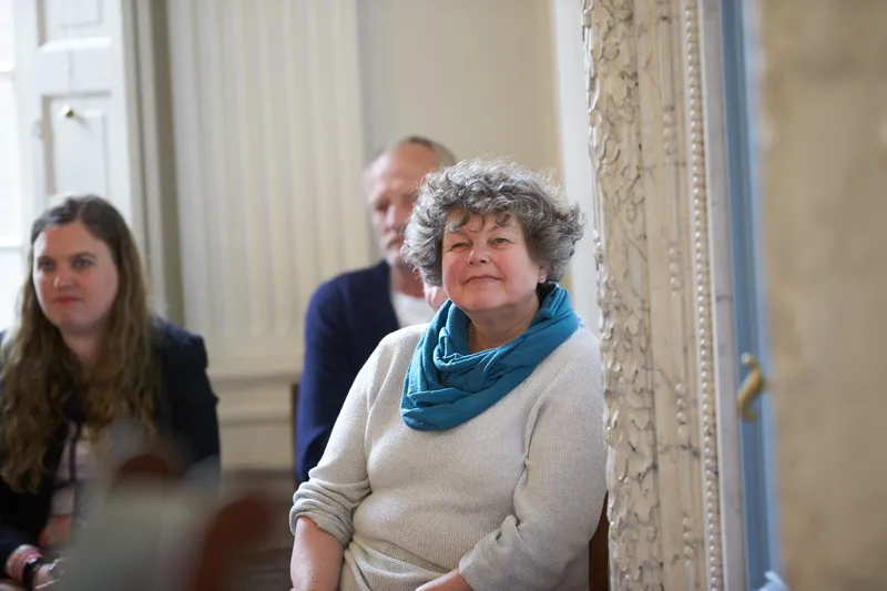 Gasten luisteren lachend naar de ceremonie