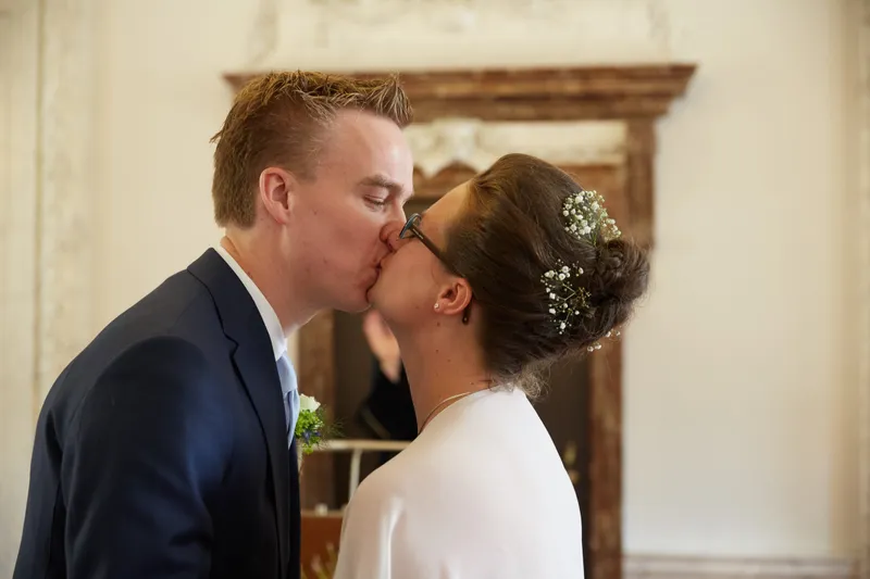Marjolein en Coen kussen elkaar in de trouwzaal