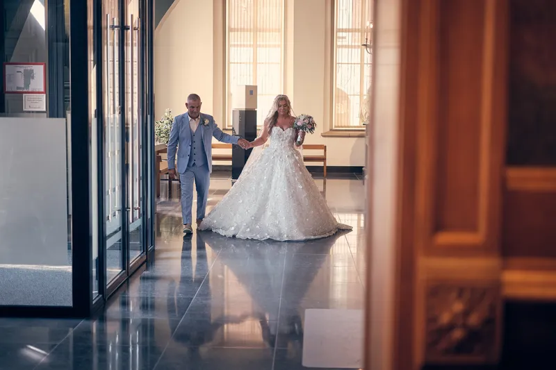 Jacky komt met haar vader binnen in het stadhuis