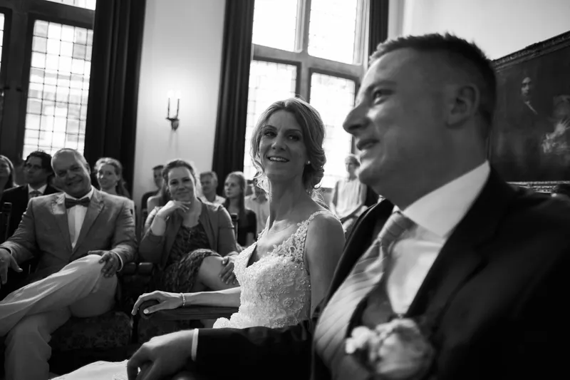 Zwart-wit: Ingrid en Richard tijdens de ceremonie, met de gasten achter hen