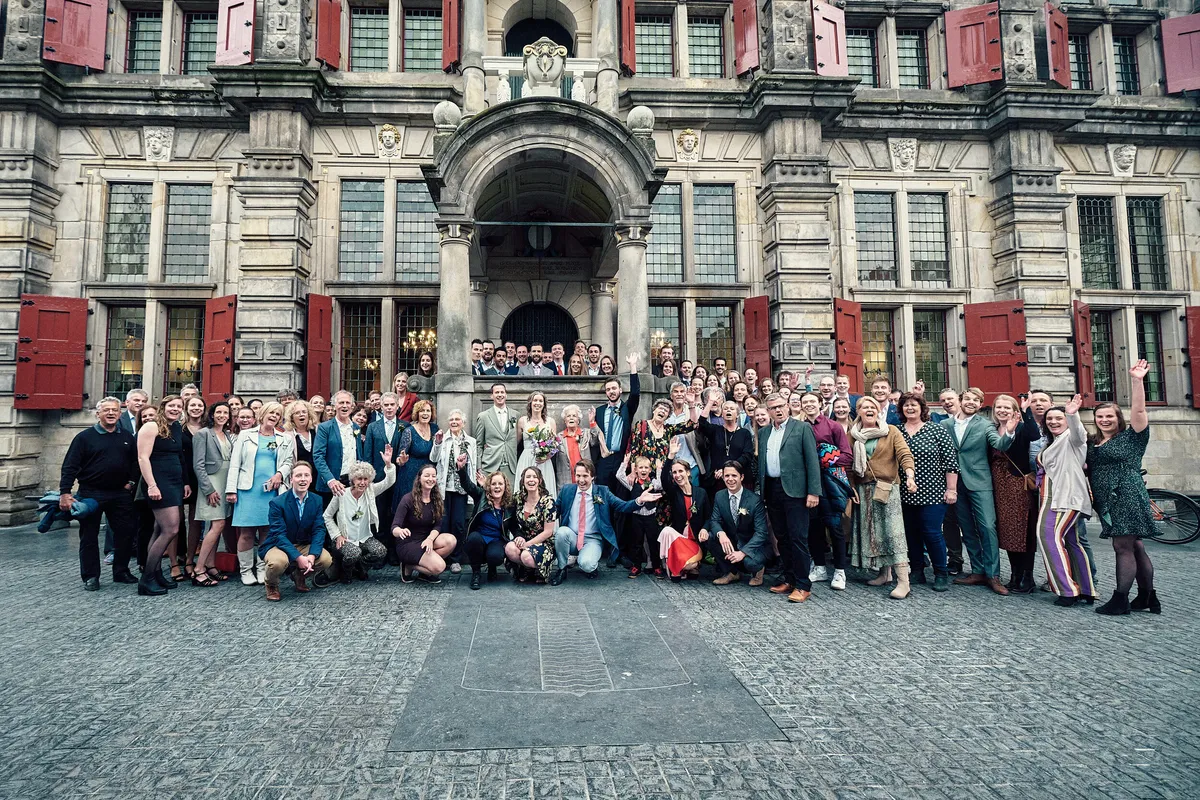 Groepsfoto van alle gasten voor het stadhuis van Delft