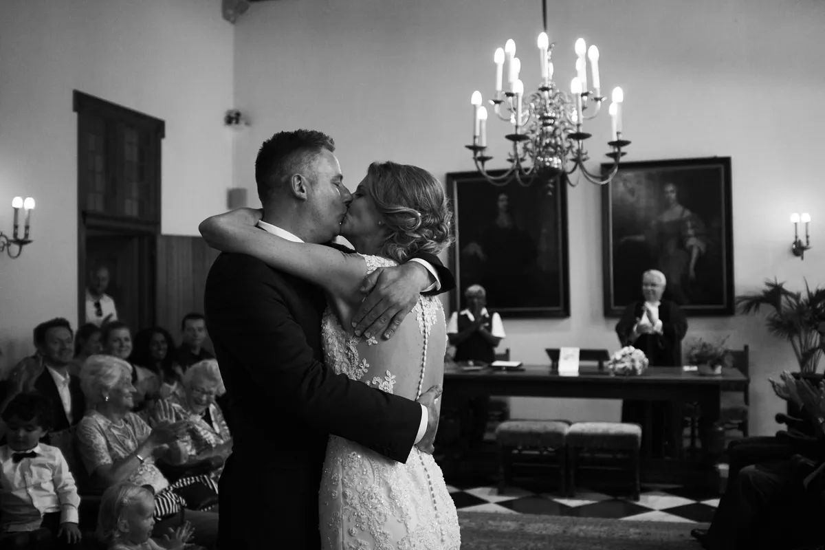 Zwart-wit: Richard en Ingrid omhelzen elkaar onder de kroonluchter