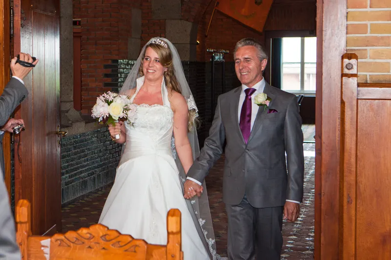 Anouk loopt aan de hand van haar vader het stadhuis binnen