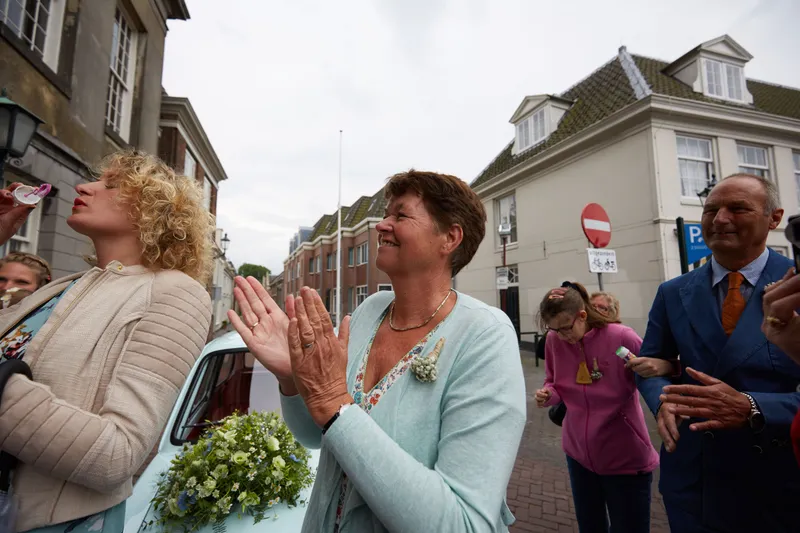 Twee gasten klappen en juichen voor het bruidspaar