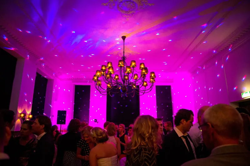 De zaal in paars licht tijdens het feest