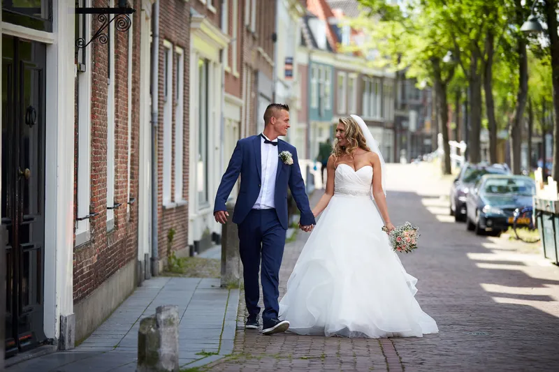 Bojaura en Jeffrey lopen door een straat met oude huizen