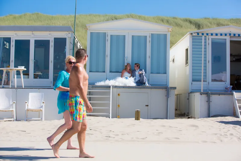 Sabine en Ferry wandelen langs de blauwe strandhuisjes