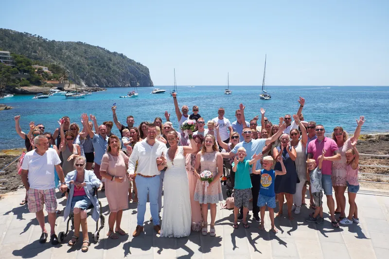 De groepsfoto met alle gasten op de rotsen in de baai