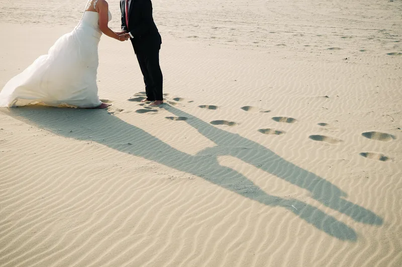 De lange schaduw van Helen en Burt op het zand