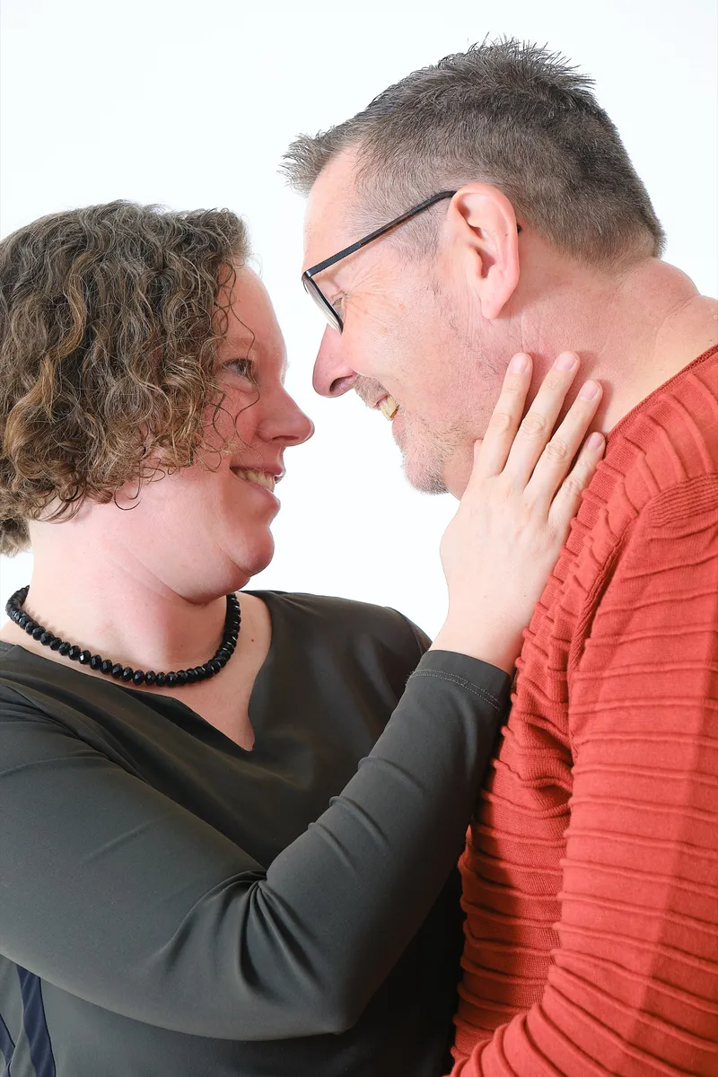 Stel kijkt elkaar lachend aan, haar hand op zijn wang