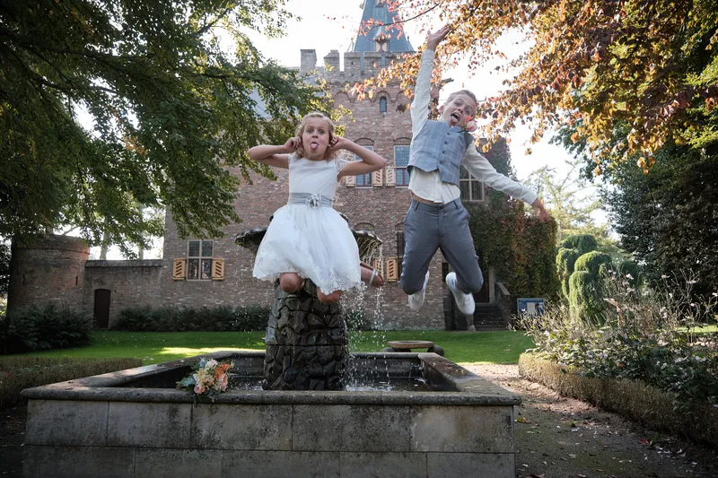 Een meisje springt op de rand van de fontein en Carlo springt mee