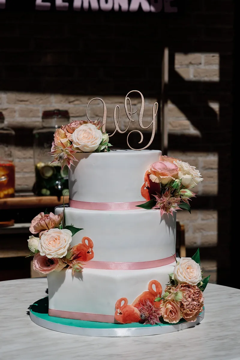 De witte taart met roze lint en rozen