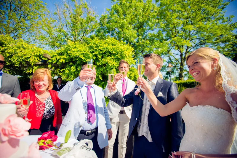 Nienke en Vincent proosten met de gasten in de tuin