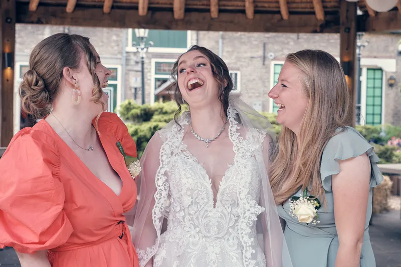 Wendy lacht met twee vriendinnen onder het rieten dak
