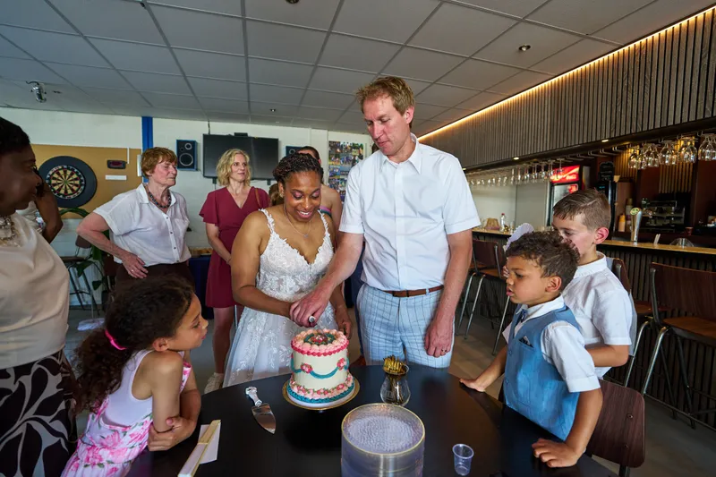 Felicia en Sander snijden de taart aan, de kinderen kijken toe