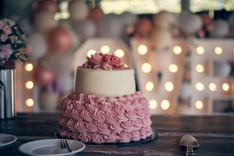 Een taart met roze rozen voor verlichte letters