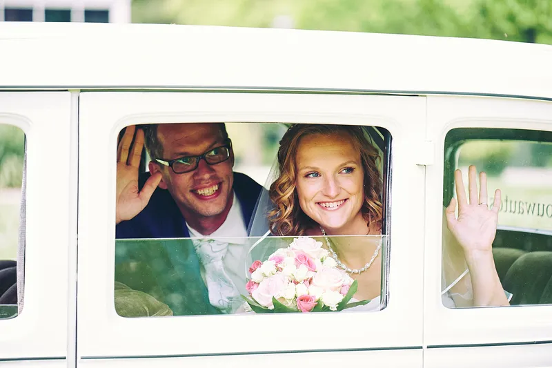 Femke en Arjan zwaaien vanuit het raampje van de auto
