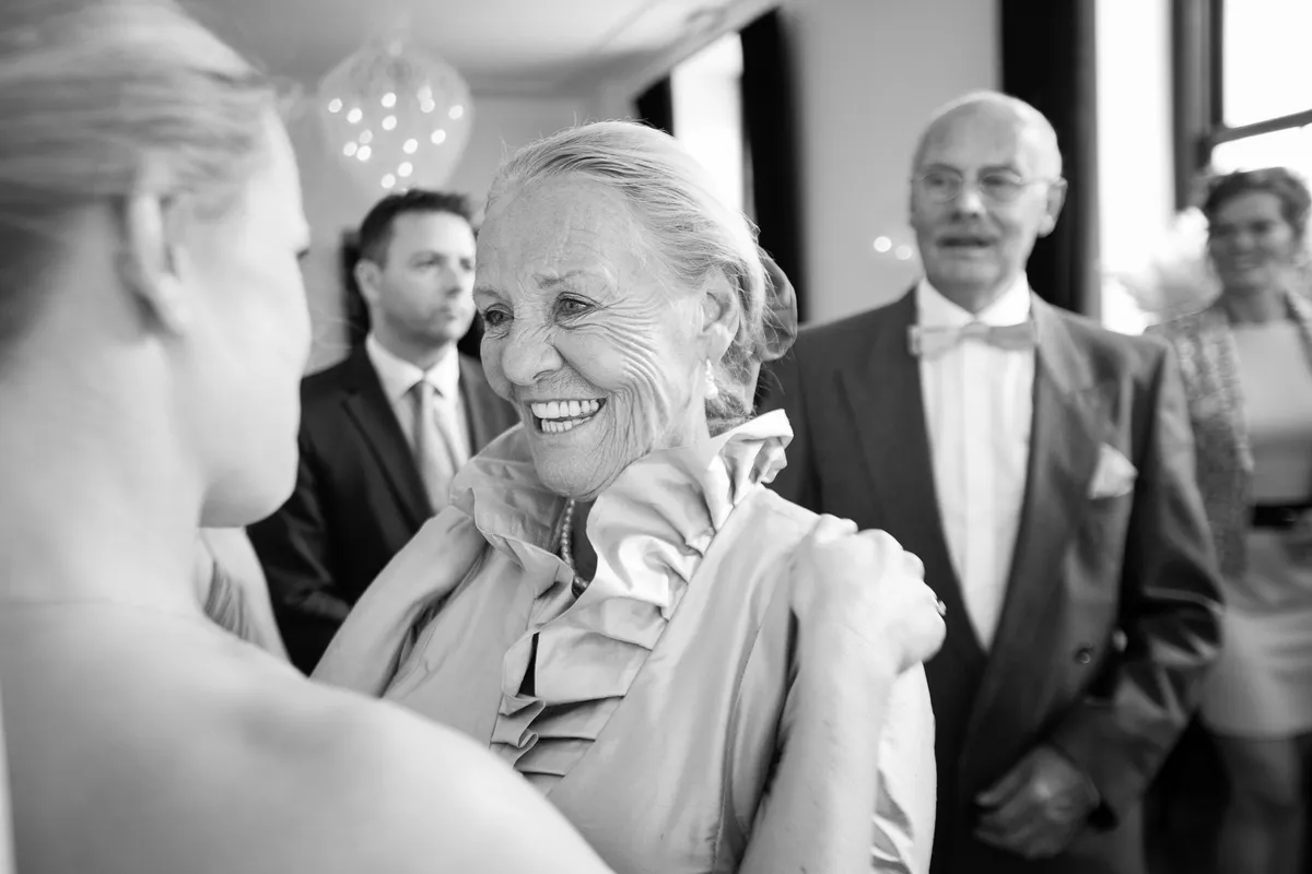 Zwart-wit: een oudere vrouw lacht bij de felicitaties