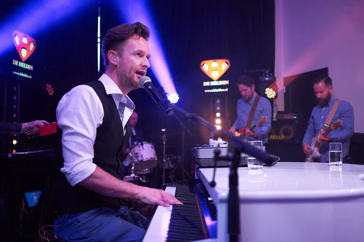 De zanger van de band achter de piano