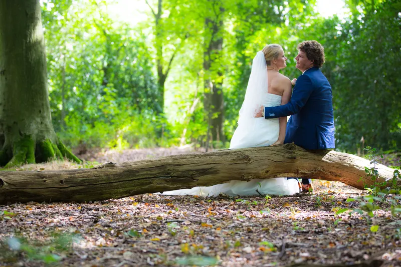 Liselotte en Matthijs op een omgevallen boomstam in het bos van Te Werve