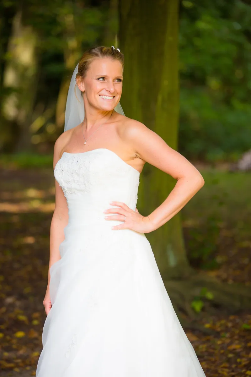 Liselotte staat met haar hand in de zij tussen de bomen